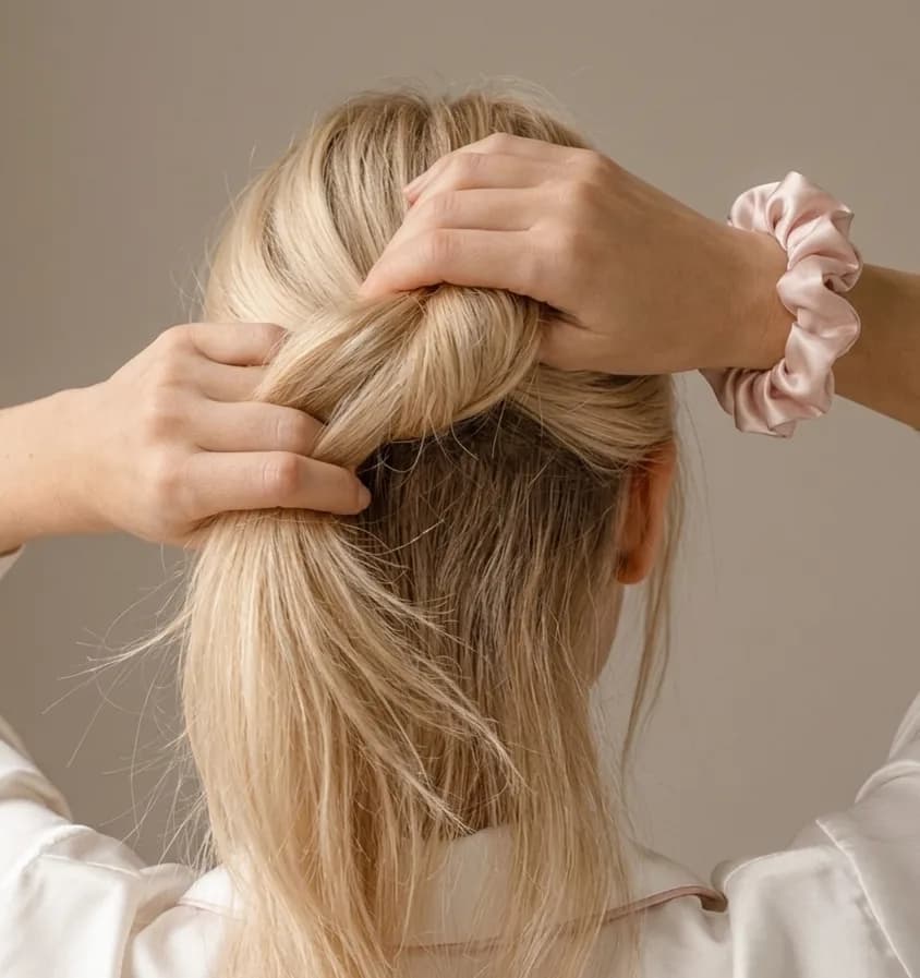 Woman gathering fine blonde hair while wearing a Kova Silk scrunchie